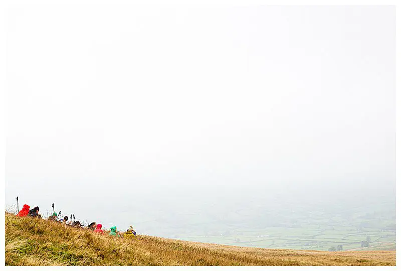 Group of walkers sitting resting in a misty Howgill Fells landscape